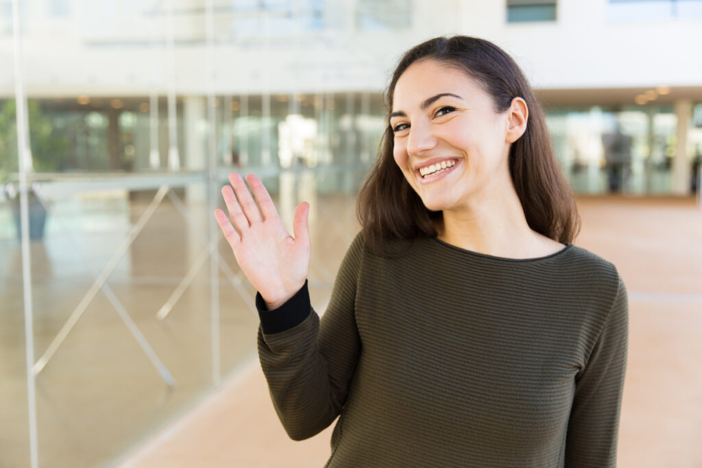 Friendly happy Latin woman waving hello